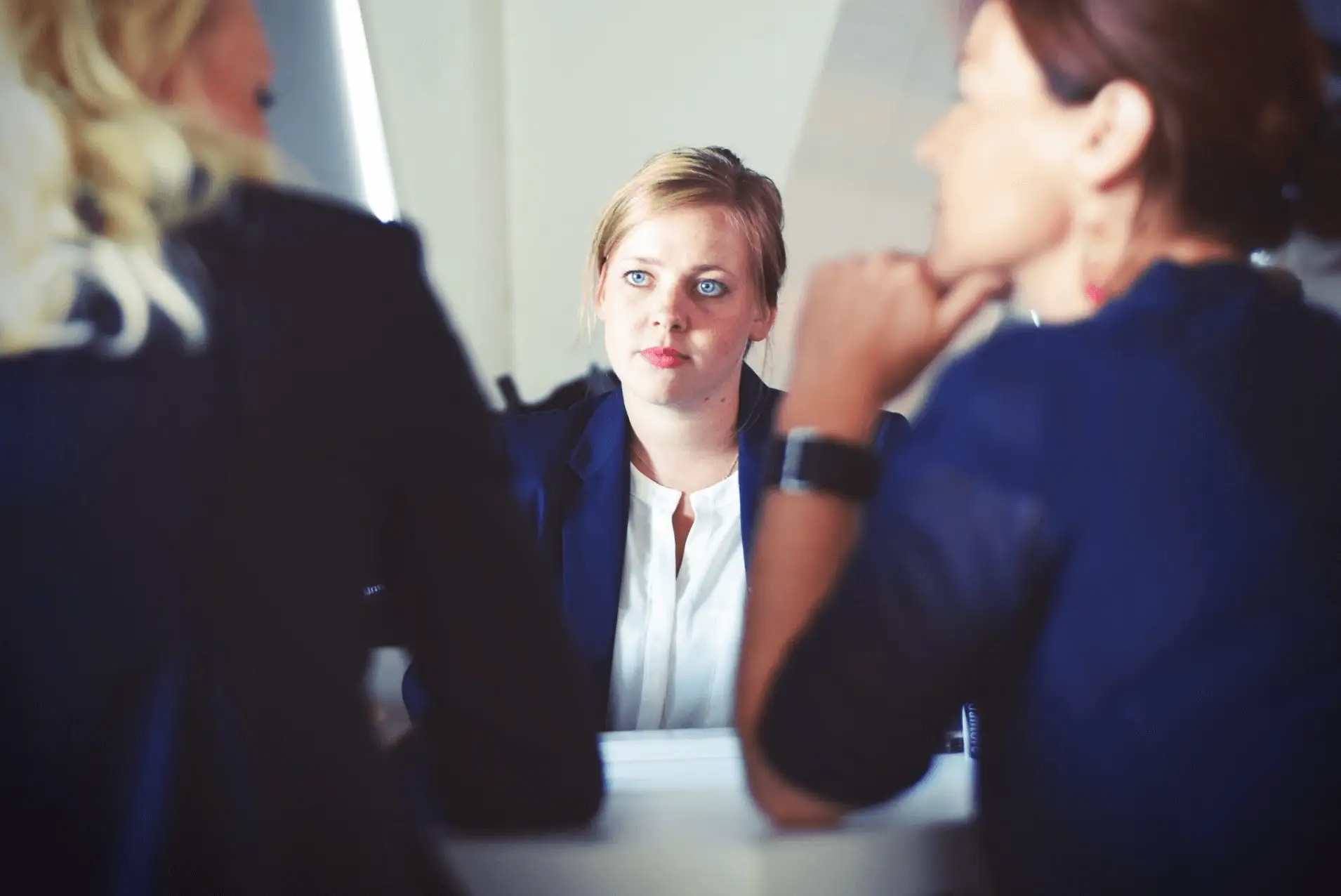 The image shows 3 woman seating on a table. 