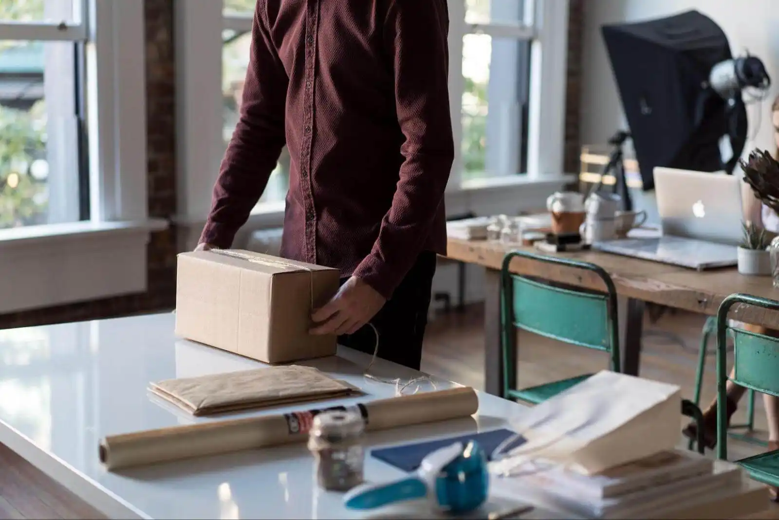 The image shows a man packing a box