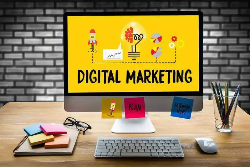 The image shows a desktop computer, on the screen it's written "Digital Marketing".
