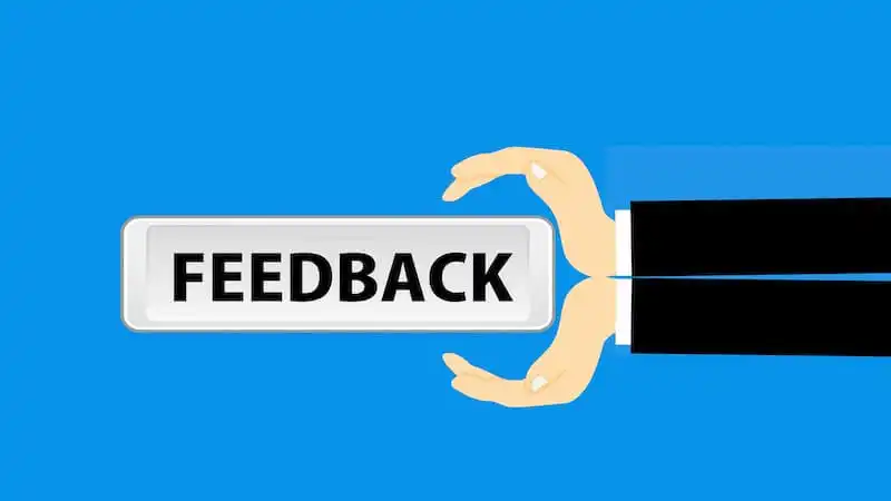  it's written feedback on a sing in the center of the image, which is held by two hands.