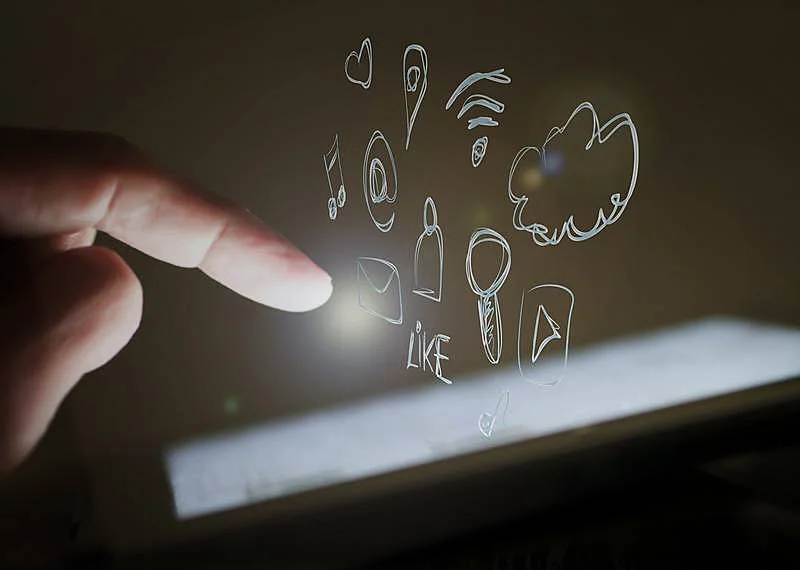 The image shows someone touchin a screen, and there are several icons coming out from the screen, such as cloud, wi-fi sign, YouTube's logo, and a heart.