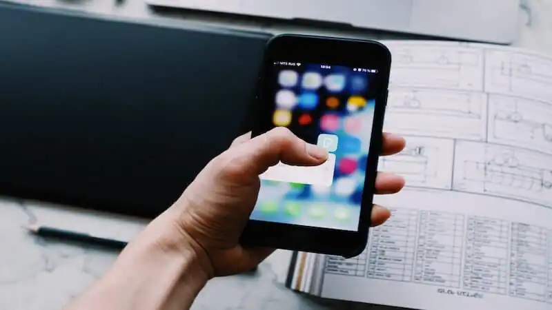 The image shows someone holding a smartphone 