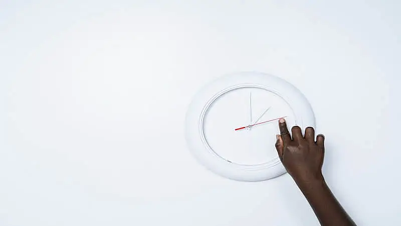The image shows someone setting the clock hands