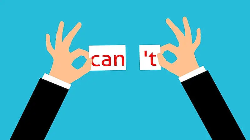 In the image there is someone holding a paper ripped in two, where it's written "can't". 