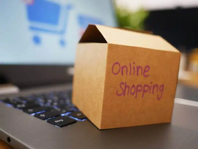Types of ecommerce - how to choose The image shows a small cart box on a laptop. On the box it's wrtitten "Online shopping".