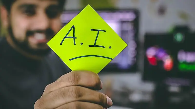 The image shows a person holding a post-it where it's written "A.I."
