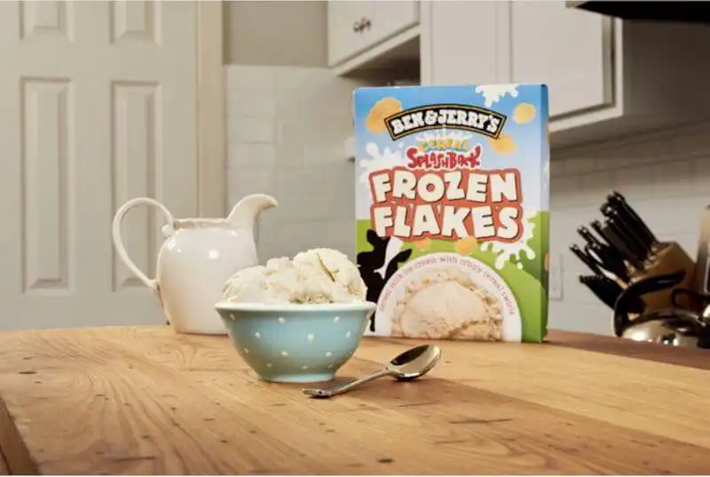 AI marketing - Ben & Jerry The image shows Ben&Jerry icecream package on a table with a bowl of ice cream in front of it and a sponn, on the side there is a jar of milk.