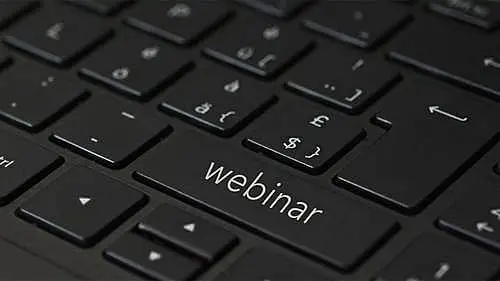 The image shows a keyboard. In one of the keyboard keys it's written "webinar".