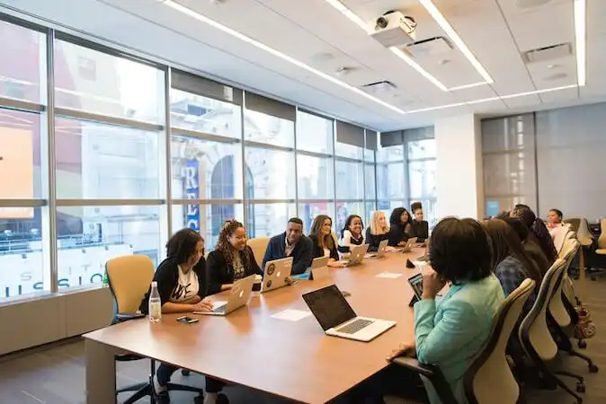 The image shows a group of people in a meeting