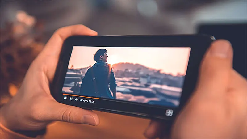 Uma pessoa segurando um celular vendo filme