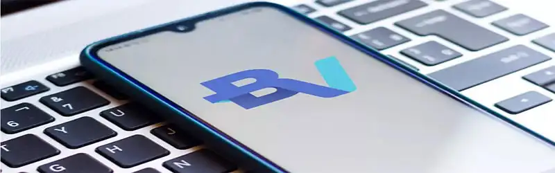 Banco digital Foto de um celular em cima de um teclado de notebook com a logo do Banco BV