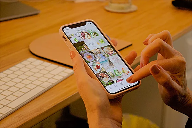 Woman holding mobile phone while browsing social media