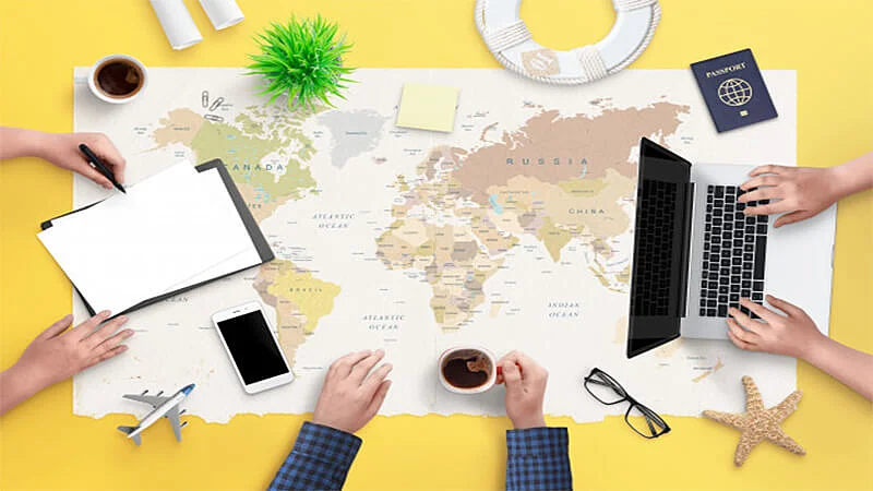 Foto de varias pessoas, um notebook, e vários detalhes de viagem