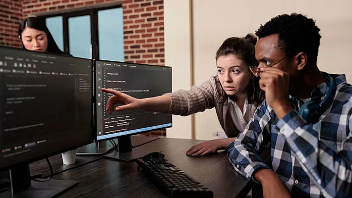 Foto de desarrolladores de sitios web estudiando el código de un sitio web