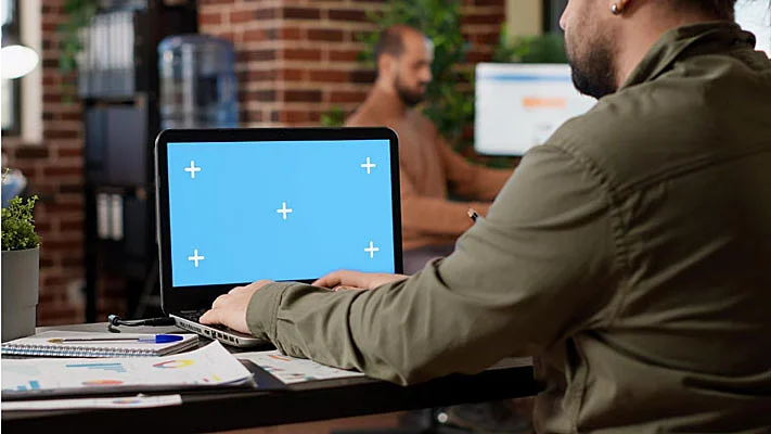 Foto de un hombre frente a un ordenador