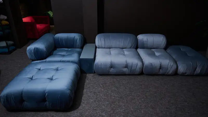 Cinema em Casa imagem de um sofá gigante na cor cinza com almofadas vermelhas