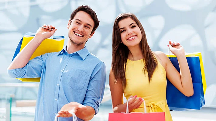 Foto de una joven pareja feliz sosteniendo una bolsa de compras