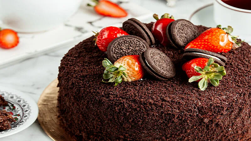 bolo de cenoura com cobertura e cenourinhas de massa americana em cima