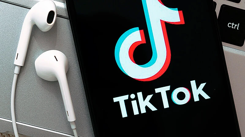 Ilustração de uma pessoa com celular e a logo do Tik Tok