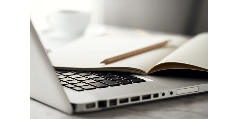 Um notebook com um caderno em cima