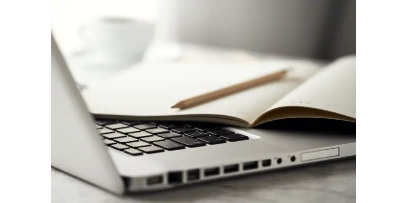 Um notebook com um caderno em cima