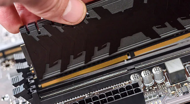 imagem que mostra uma pessoa instalando um pente de memória RAM em uma placa mãe