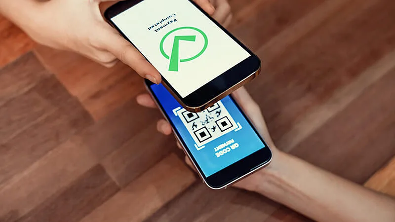 Foto de duas pessoas segurando celular enviando dinheiro