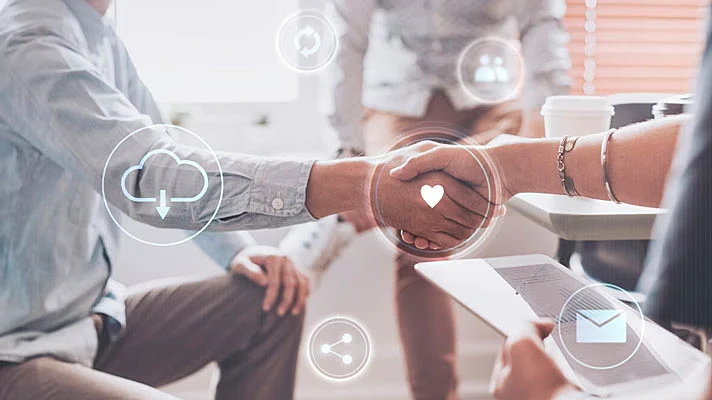 foto de dos personas dándose la mano con una proyección de iconos de estrategias de CRM como el marketing por correo electrónico