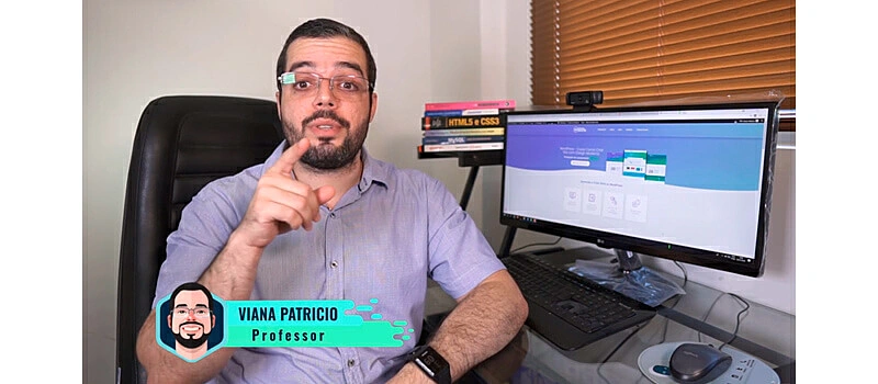 professor do curso para criar site Viana Patricio ao lado de um monitor