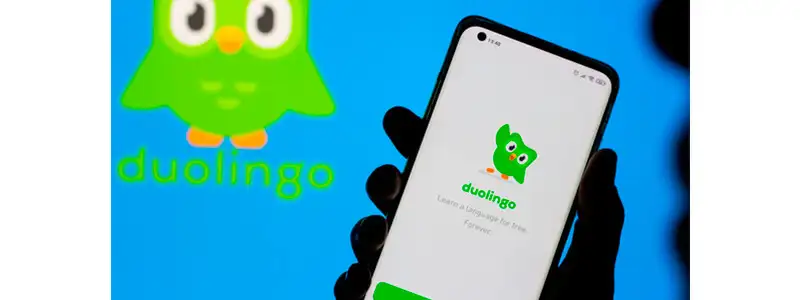 mão segurando um celular com o app do duolingo aberto