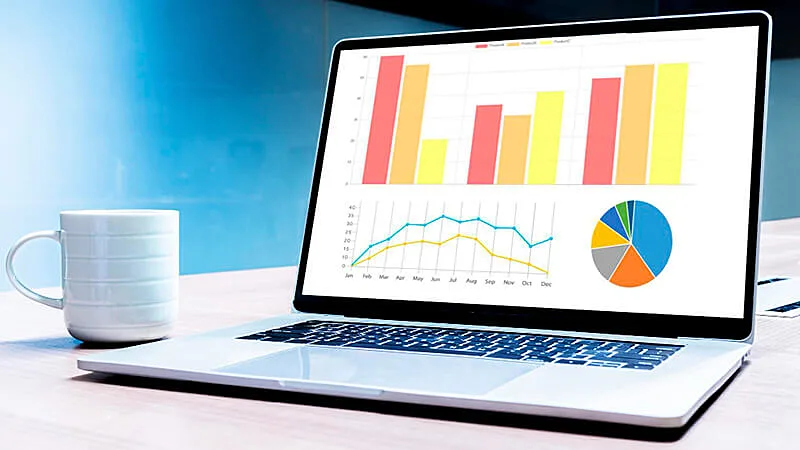 Um notebook em cima de uma mesa com diversos gráficos na tela