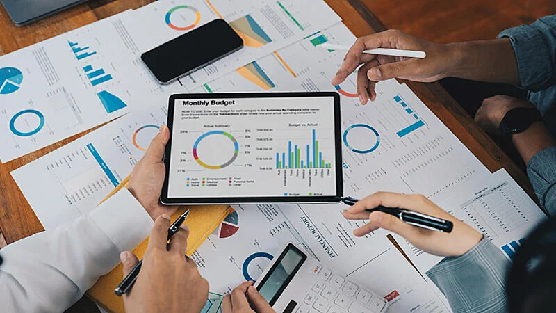 Foto de duas pessoas analisando gráficos em uma folha