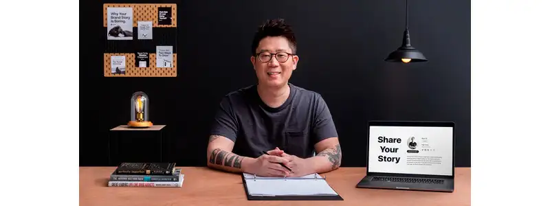 instrutor do curso de storytelling em uma mesa com notebook, fichário e livros