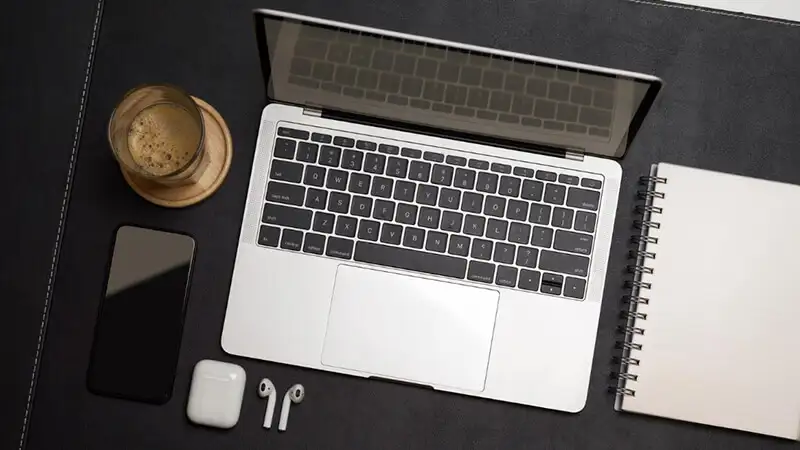 Curso em vídeo Uma foto de um notebook, canetas e um bloco de anotação em cima de uma mesa