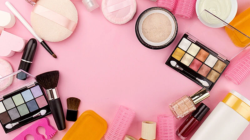 Foto de várias maquiagem em cima de um fundo rosa