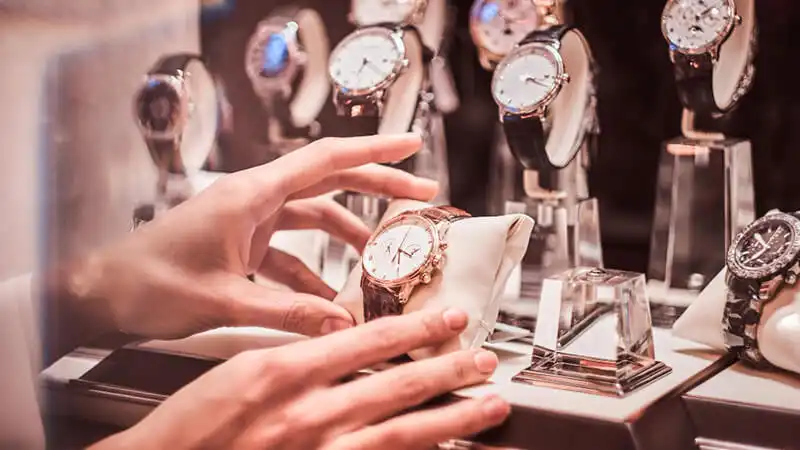 Foto de uma pessoa segurando um relógio em um mostruário