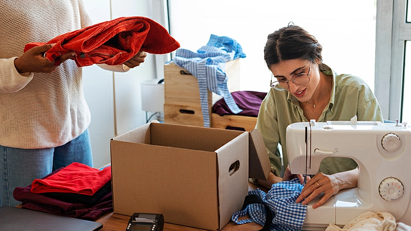 Foto de uma pessoa colocando roupas em uma caixa