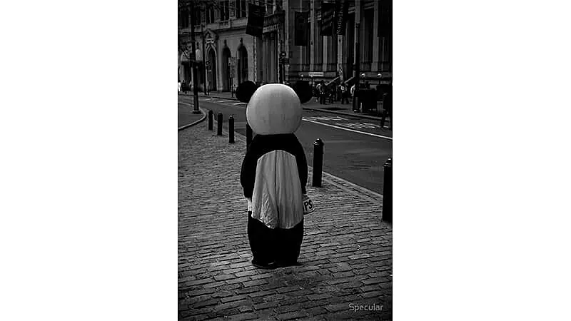foto em preto e branco de uma pessoa vestida em um fantasia de panda no meio de uma rua