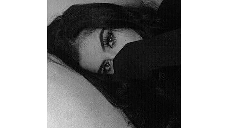 foto em preto de branco de uma garota com a mão na boca