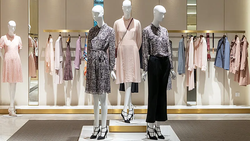 Foto de manequins e araras com roupas em uma loja