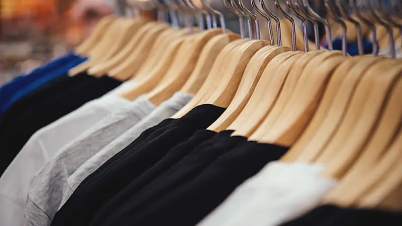 Foto de uma arara com diversas roupas penduradas