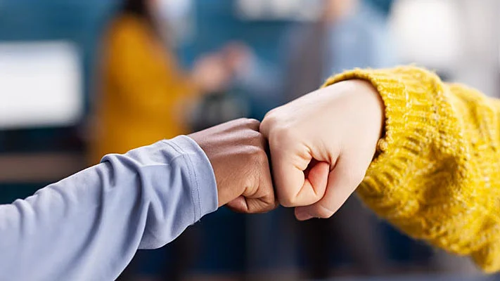 Foto de amigos salundándose con un puñetazo