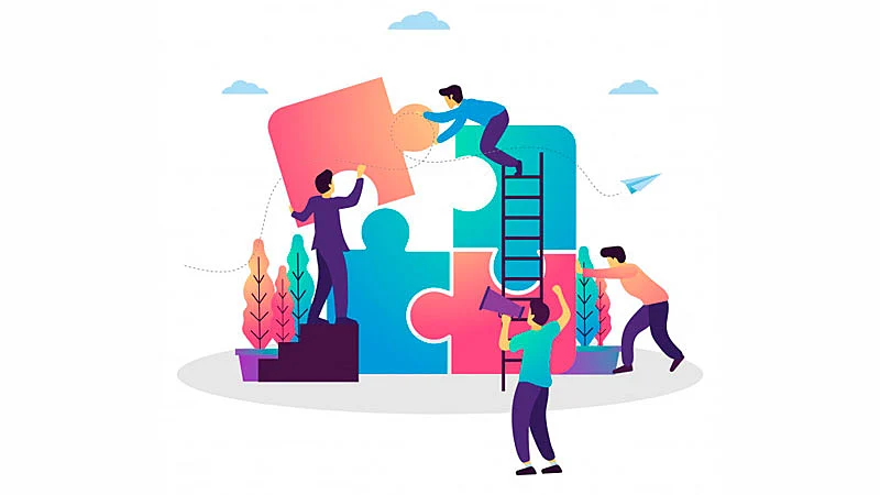 Colaboradores recebendo instruções de um líder para montar um quebra cabeça