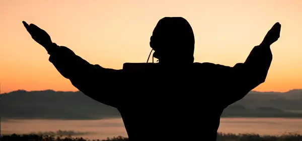Silhueta de uma mulher lendo um livro no por do sol