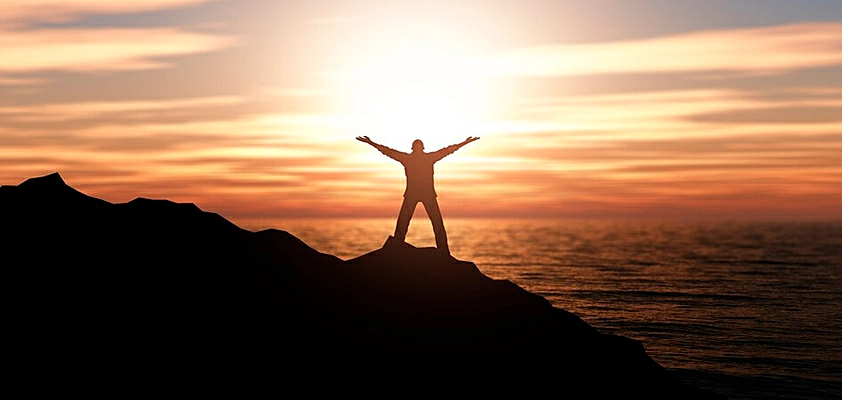 Foto de um homem pulando de uma pedra em direção a outra
