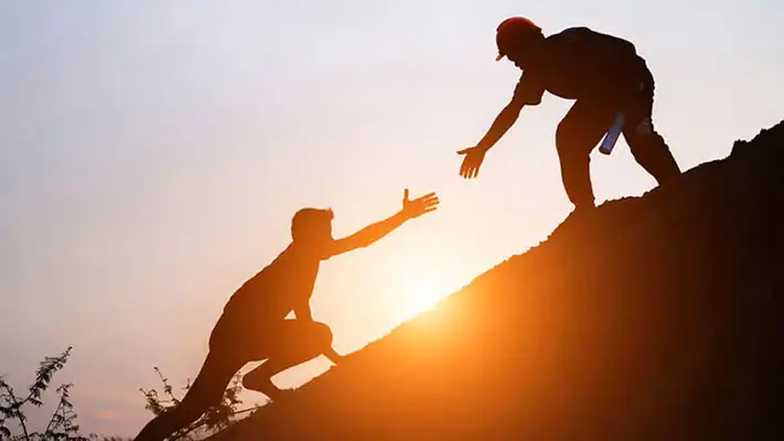 Frases de superación Foto de un hombre acercándose a otro para ayudarlo a subir una colina