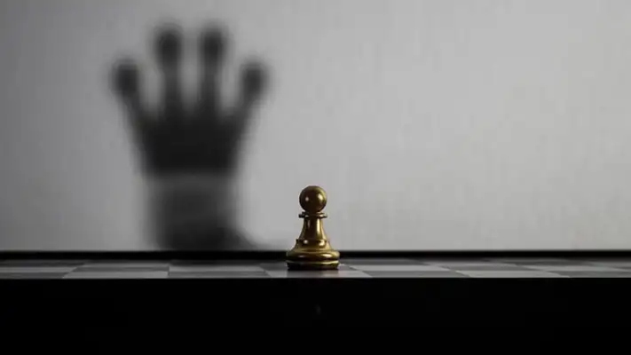 Frases de superación Foto de un tablero de ajedrez con una pieza de peón con una sombra de reina