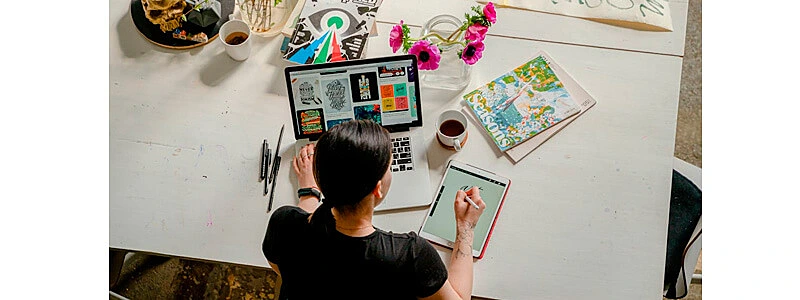 ideia de como ganhar dinheiro em casa sendo ilustrada por uma designer trabalhando com notebook e tablet