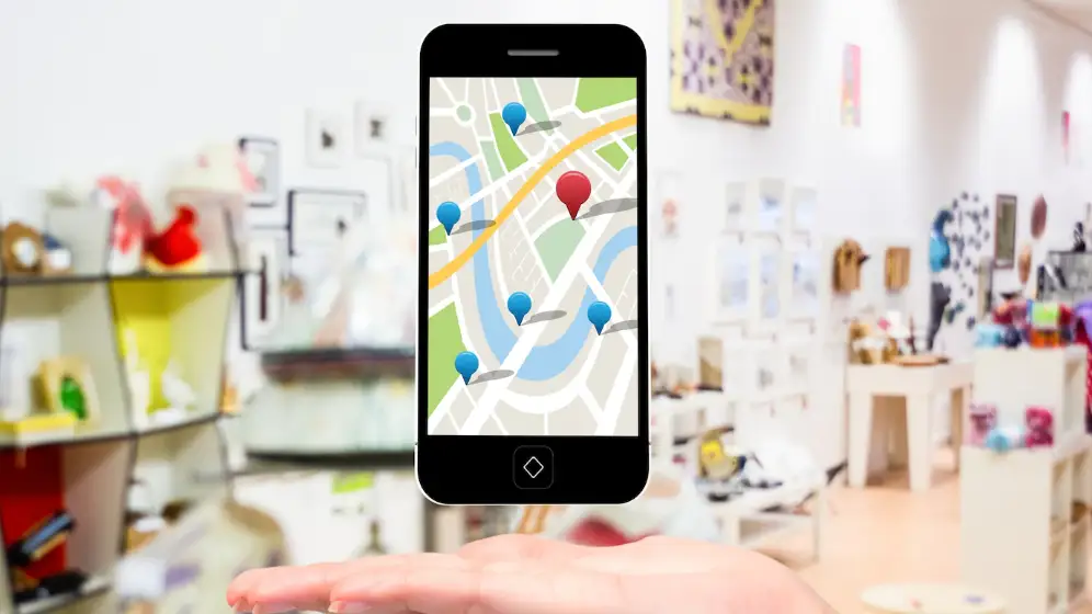 Foto de una tienda de fondo y superpuesta, la imagen de un teléfono móvil con visualización de Google Maps