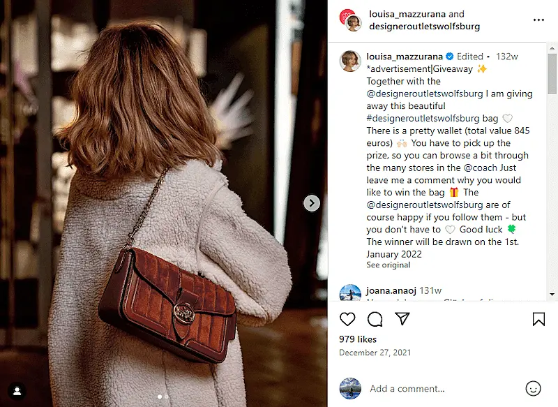 Louisa Mazzurana post showing a photo of her using a brown purse, and wearing a cardigan.